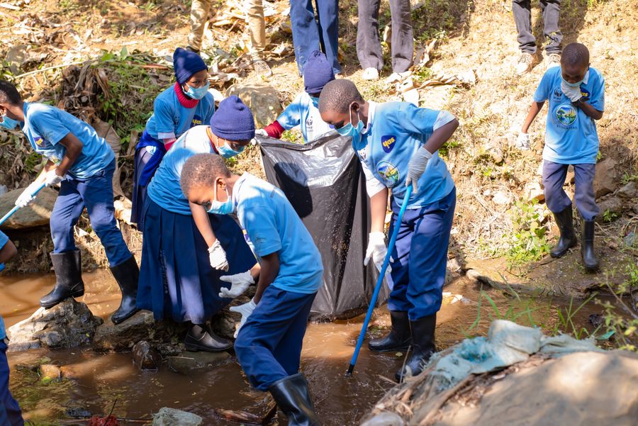 Students and facilitators filling the first waste bag during a KIWI river cleanup