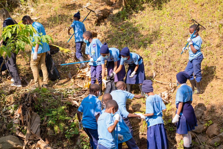 Students collecting waste from a streambed during a KIWI community river cleanup