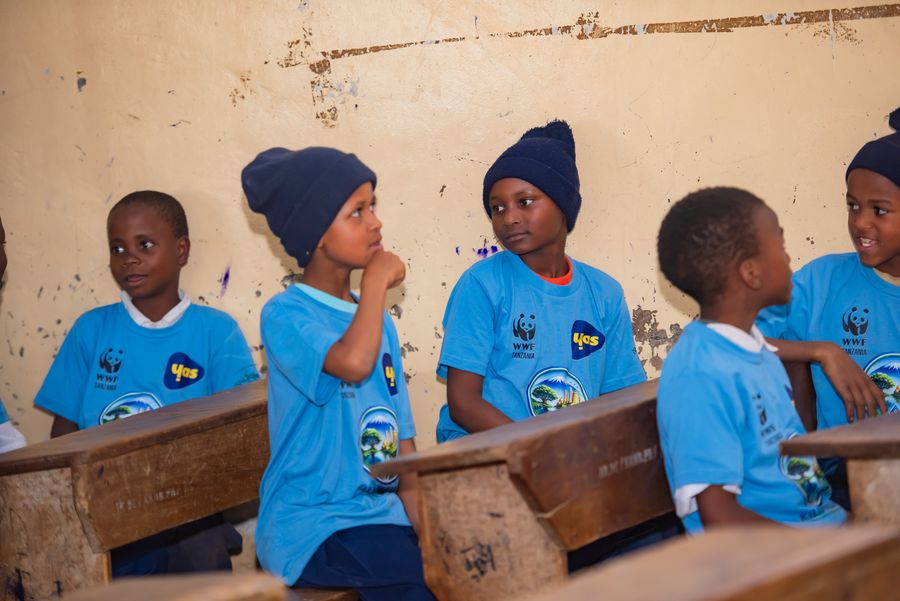 Four students listening attentively at the front of a KIWI classroom water session