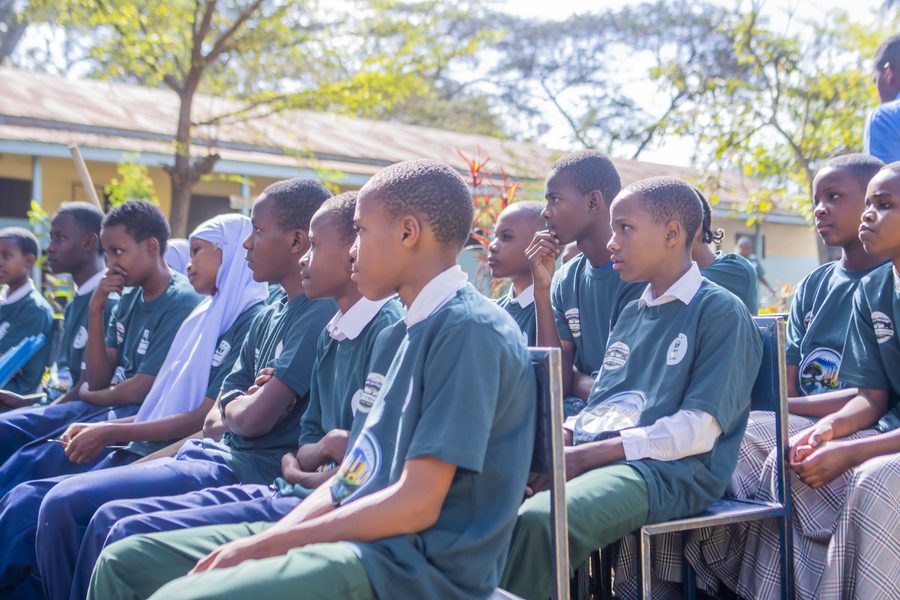 Students in KIWI shirts seated together during a school water education session