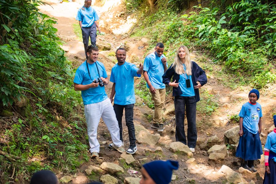 KIWI facilitators and students standing together in a shallow Kilimanjaro stream